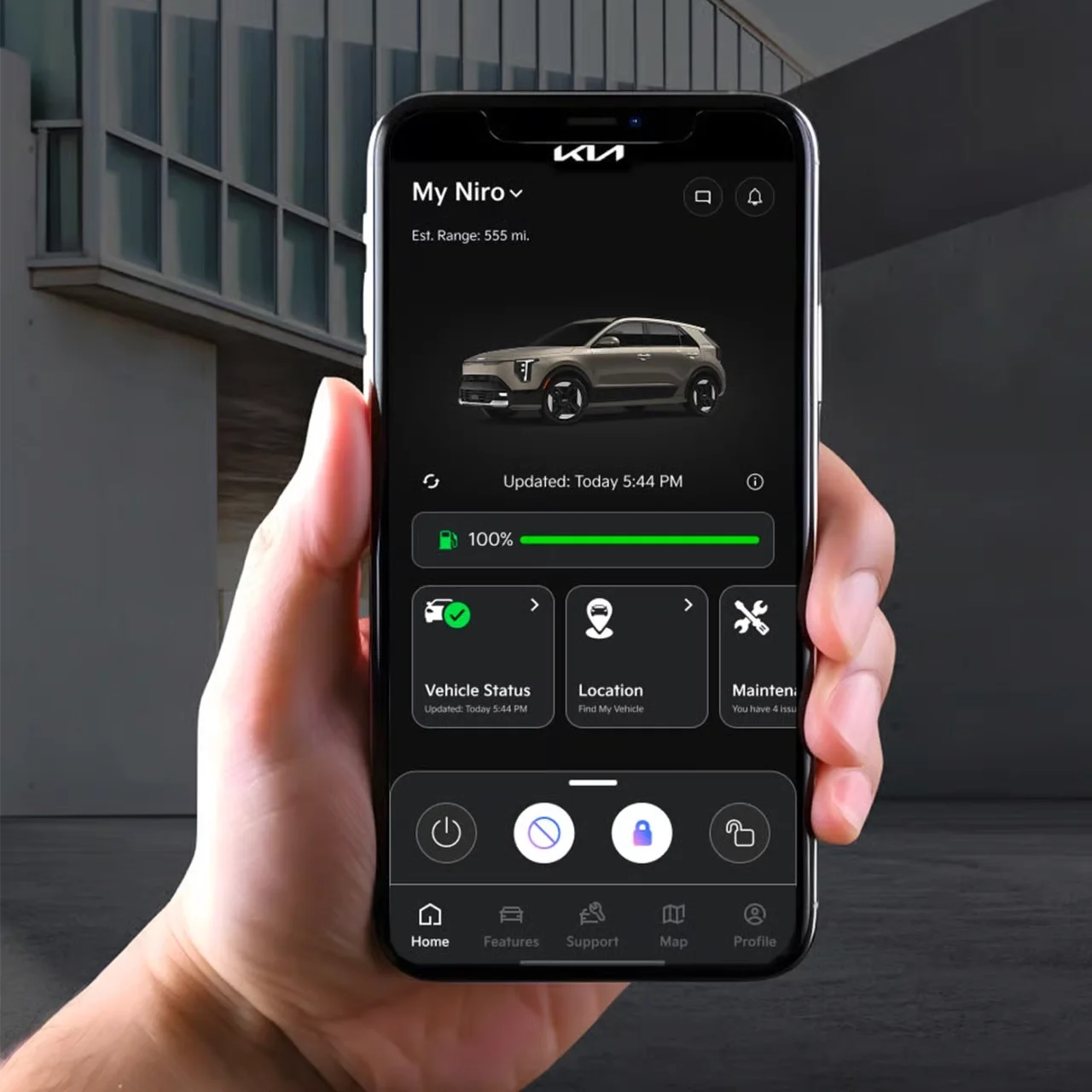 Kia Connect app shown on a smartphone in front of a 2027 Kia Niro Hybrid